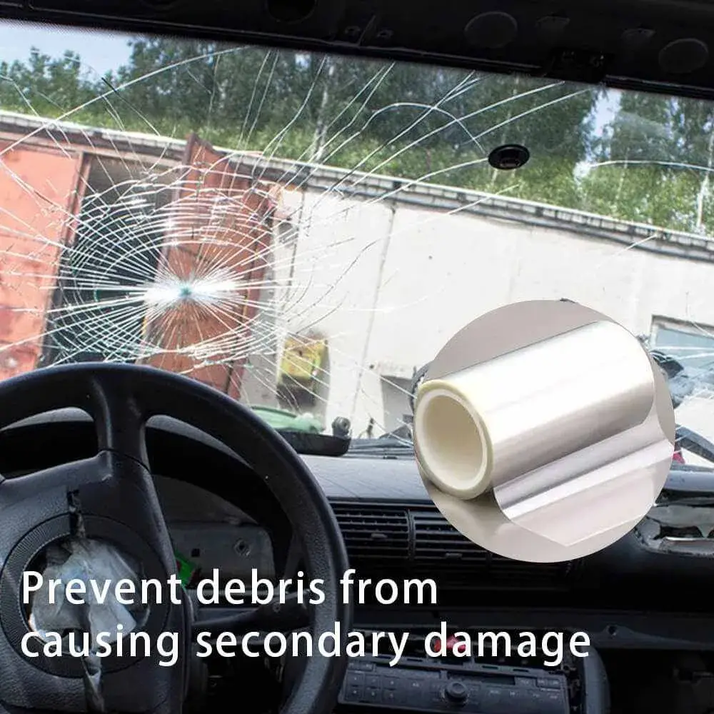 Car window with shattered glass protected by explosion-proof film, with film roll in foreground